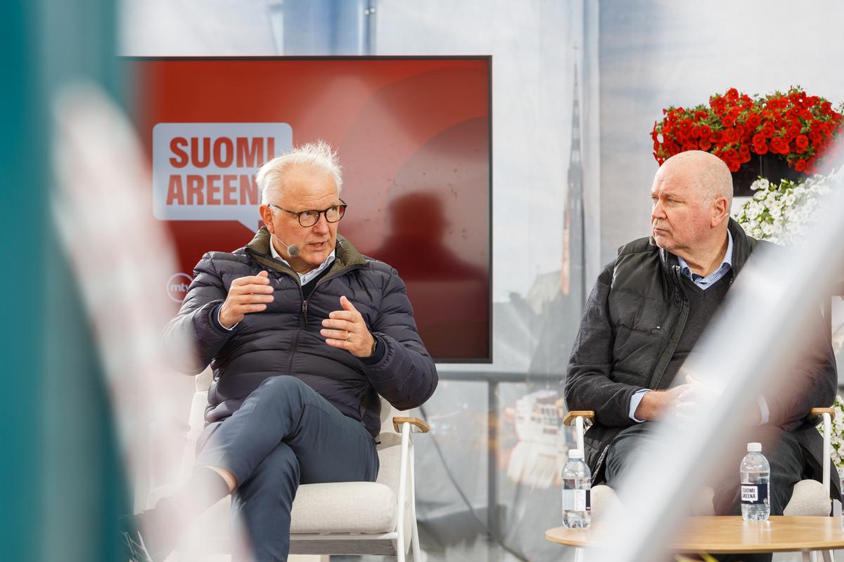 Olli Rehn ja Eero Heinäluoma keskustelevat esiintymislavalla.