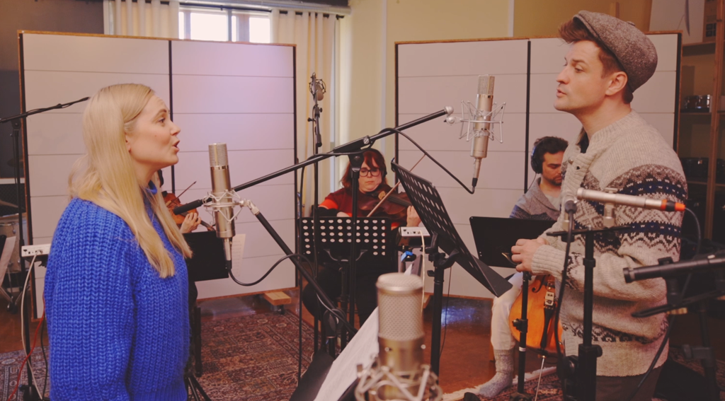 Minja Koski ja Mikael Saari laulavat studiolla, taustalla soittaa jousikvartetti.