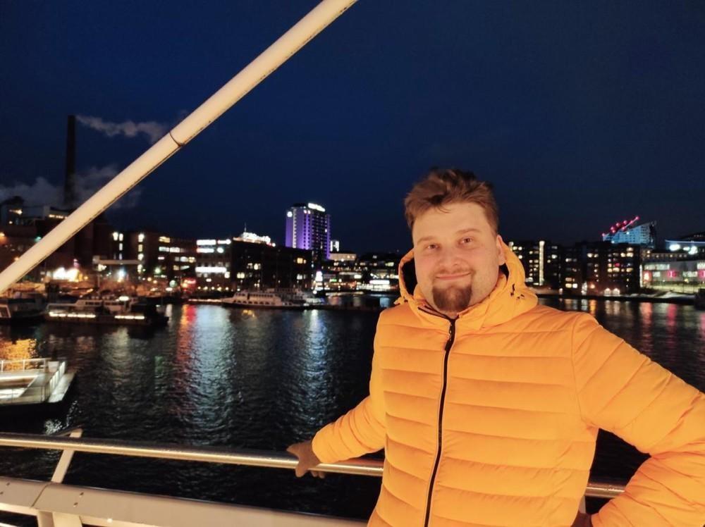 Niku Hinkka, jonka taustalla yöllistä näkymää kaupunkiin ja satamaan.