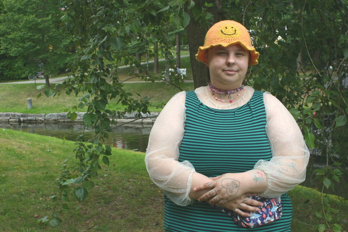 Tuuli Aitchison taustanaan vehreä kesäinen maisema.