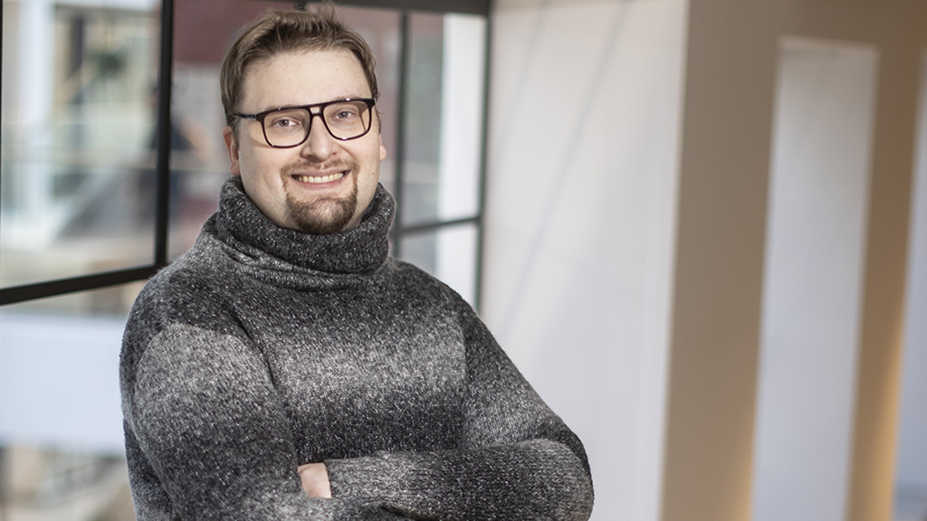 Niku Hinkka hymyilee käden puuskassa ikkunan edessä.