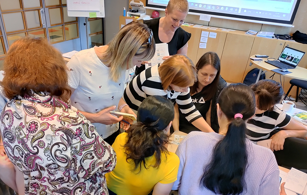 Koulutuksessa ryhmä ukrainalaisia on kokoontunut tiiviisti yhteisen tehtävän äärelle.