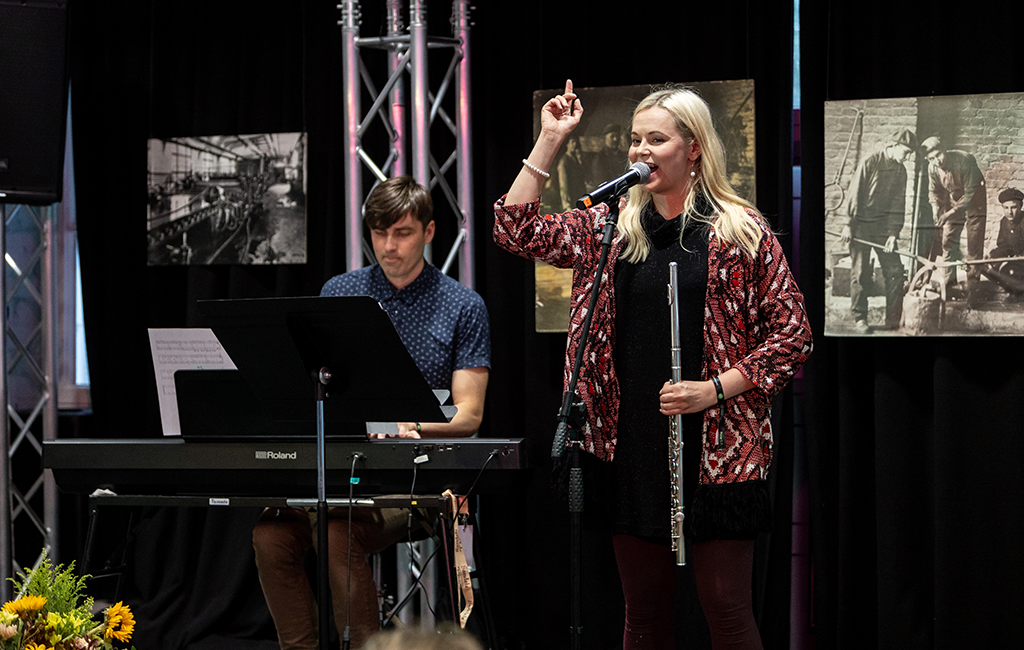 Minja Koski laulaa esiintymislavalla, taustalla Viljami Viippola soittaa kosketinsoittimia.