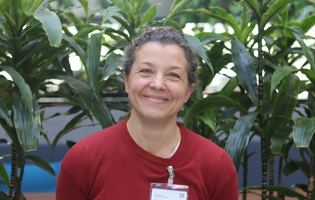 Punapaitainen nainen puolivartalokuvassa.