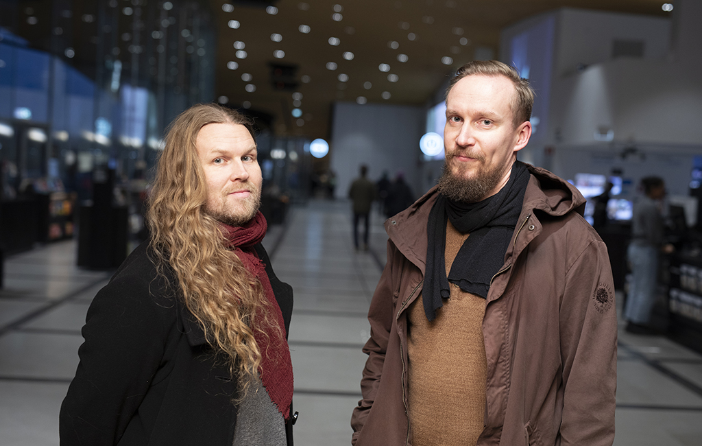 Kaksi miestä seisoo käytävällä.