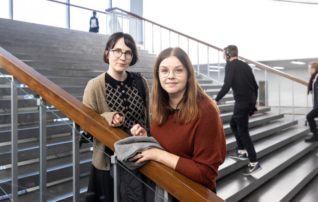 Kaksi nuorta naista seisoo yliopiston rappusilla.